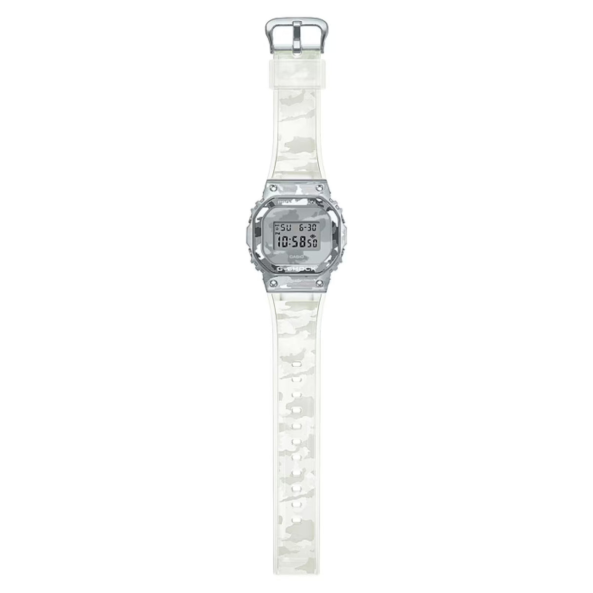 Full length flat lay of the Casio G-Shock GM-5600SCM-1 digital watch, highlighting the complete translucent camouflage strap and square silver-tone case.