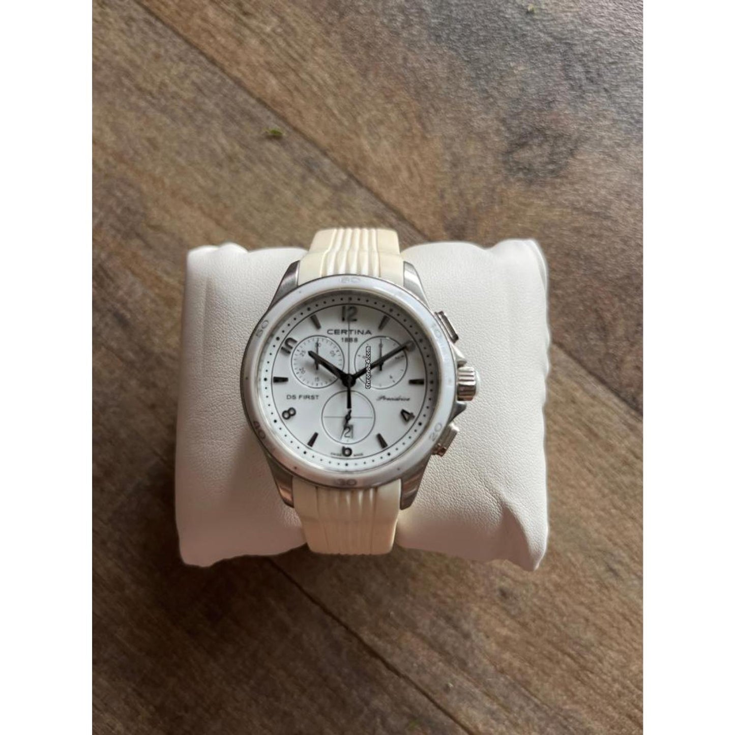 Certina DS First Lady Chronograph C030.217.17.017.00 sobre cojín, con esfera blanca, subesferas de cronógrafo y correa blanca de caucho.