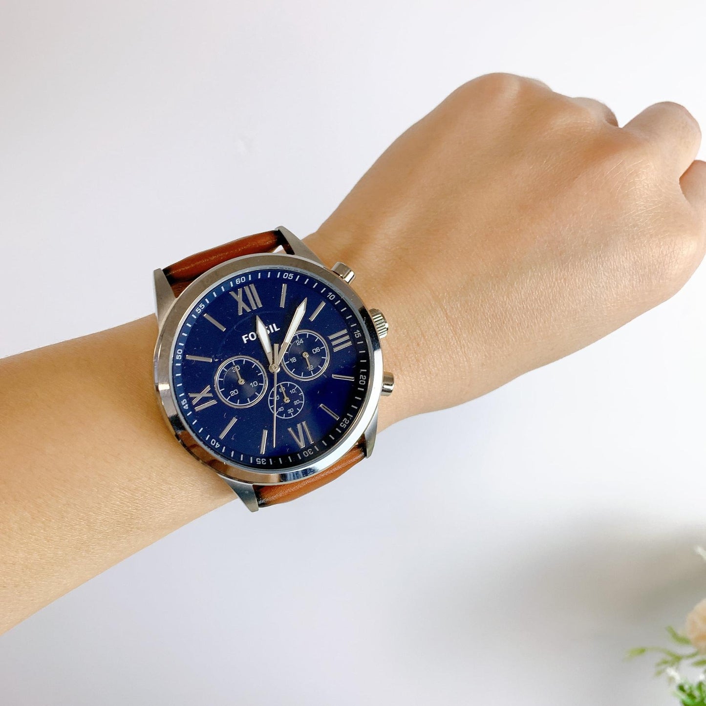 Fossil BQ2125IE chronograph watch with blue dial, silver-tone case, and brown leather strap worn on the wrist in a casual everyday style.
