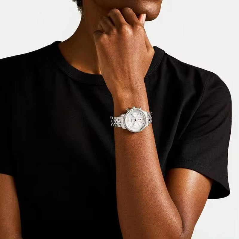 Reloj Fossil Neutra ES5357 cronógrafo de acero y esfera madreperla, puesto en la muñeca de mujer con camiseta negra, vista frontal.