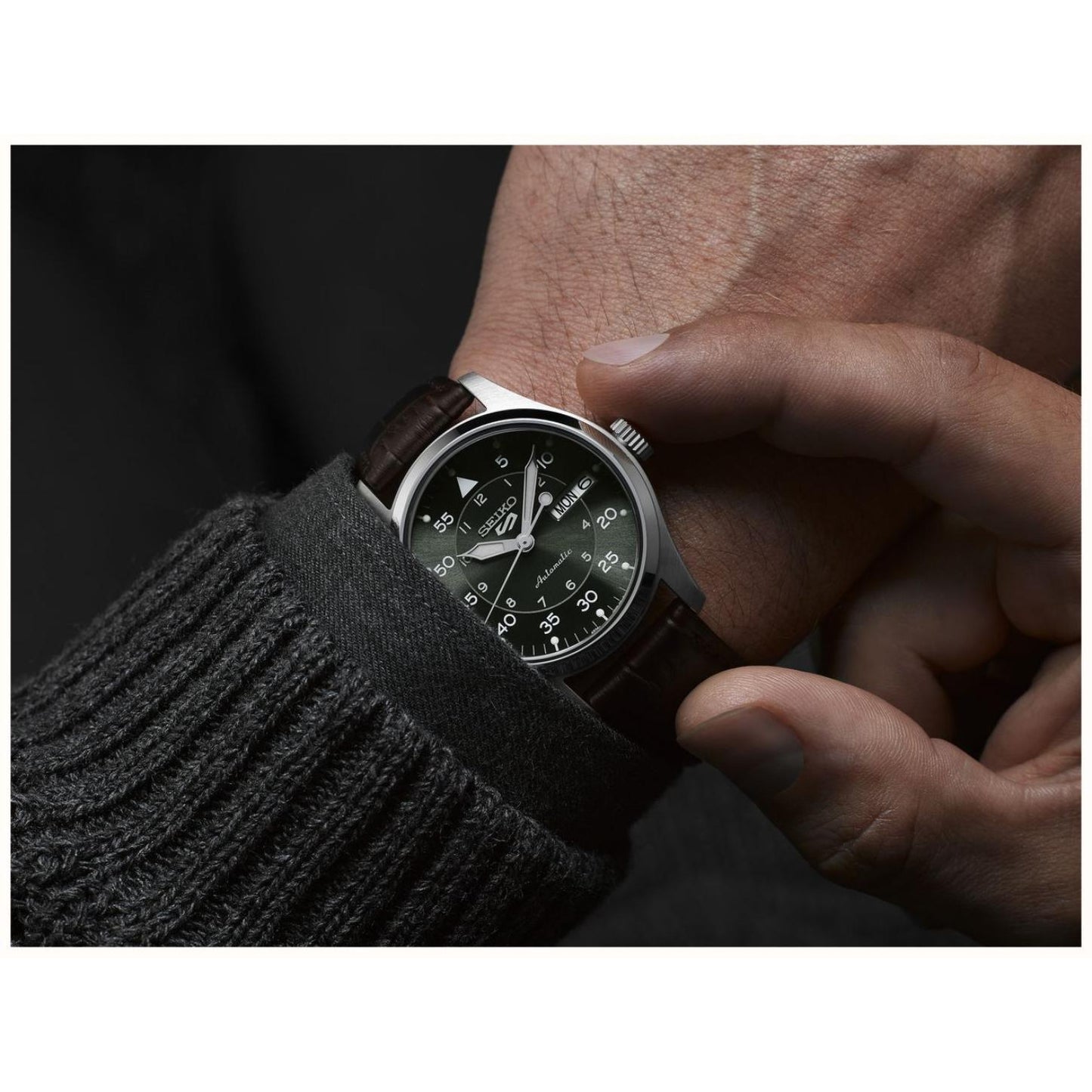Seiko SRPJ89K1 mens automatic field watch with green dial and brown leather strap worn on wrist in close up detail