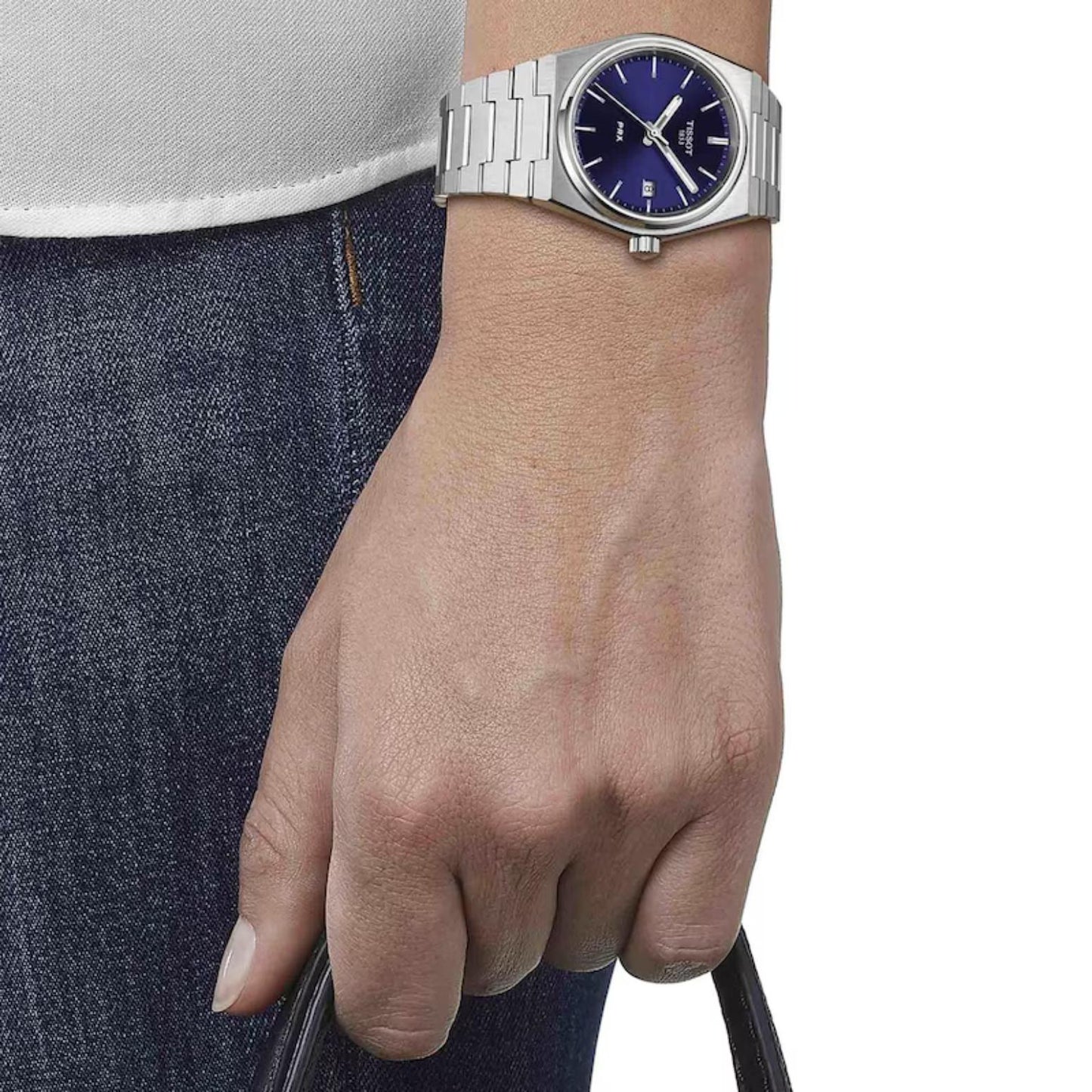 Tissot PRX T137.210.11.041.00 with blue sunray dial, slim stainless steel case, and integrated brushed steel bracelet worn on the wrist.