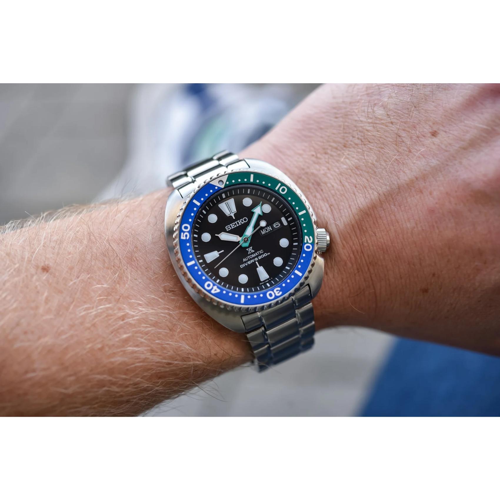 Seiko Prospex SRPJ35 automatic dive watch worn on wrist with black dial, Tropical Lagoon blue-green bezel and stainless steel bracelet.