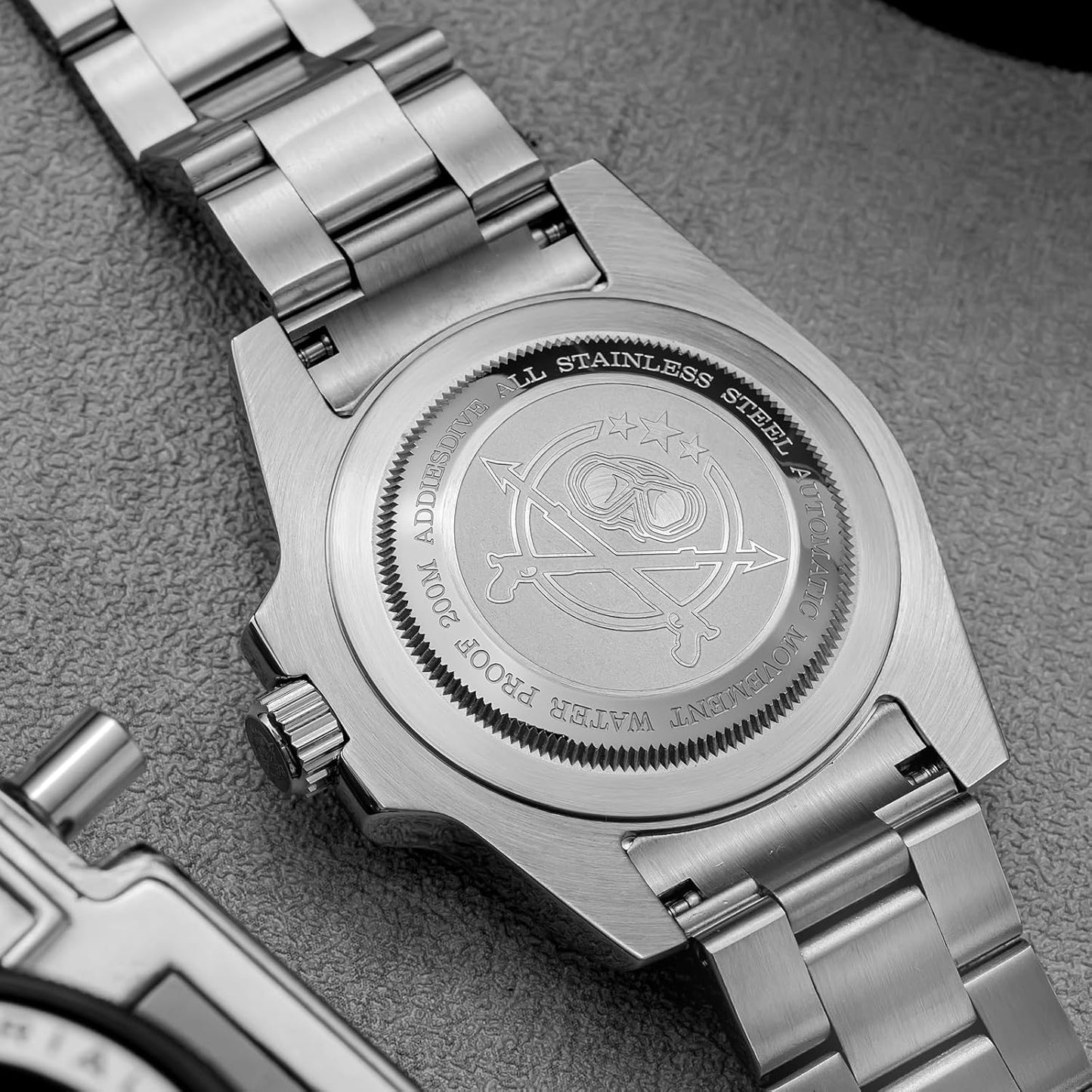 Vista trasera del reloj Addiesdive automático mostrando la tapa de acero inoxidable grabada y el brazalete metálico.