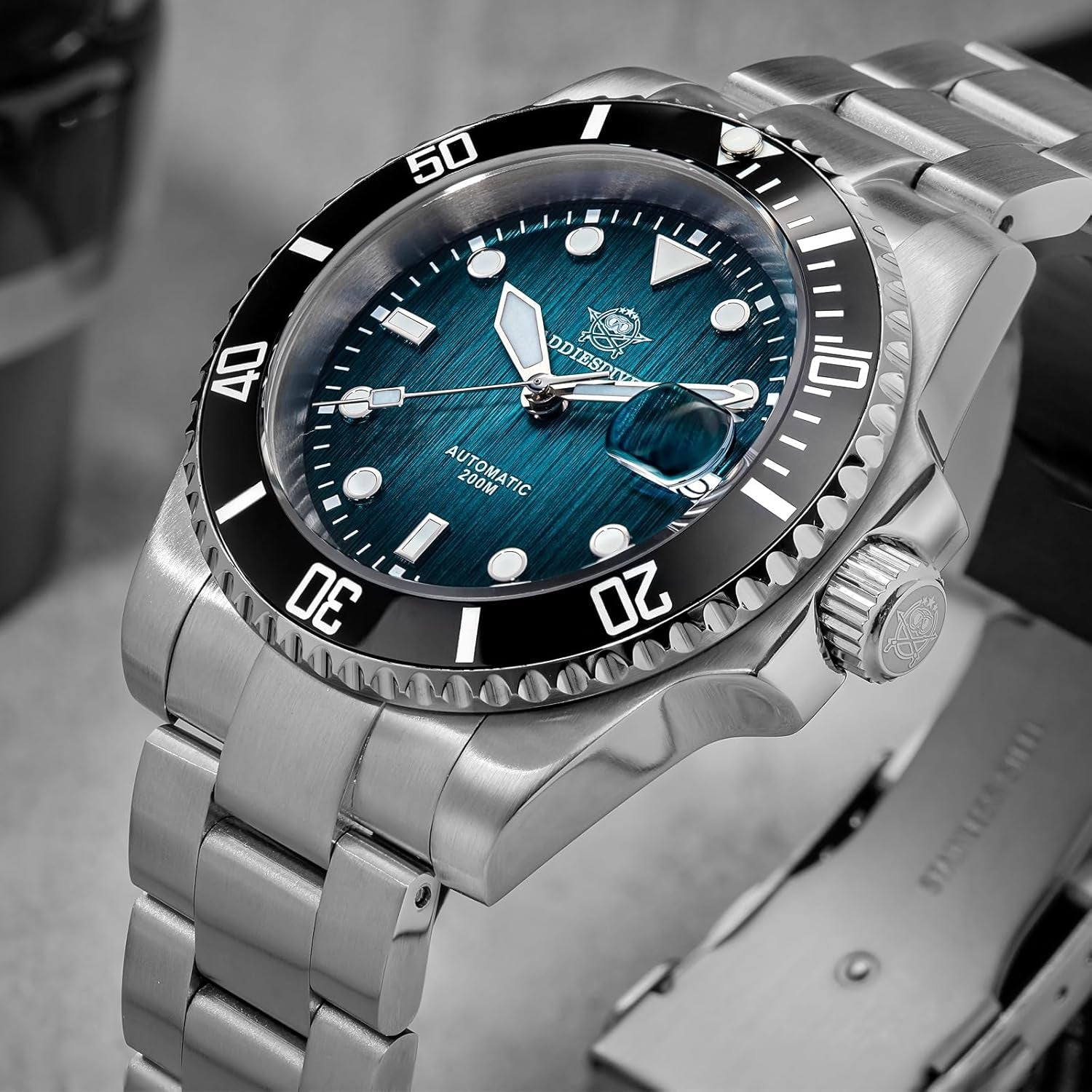 Reloj Addiesdive automático con esfera azul y brazalete de acero visto en perspectiva inclinada, mostrando la corona y el bisel negro giratorio.