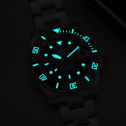 Reloj Addiesdive automático visto en oscuridad, mostrando los índices y agujas iluminados con brillo luminescente azul.