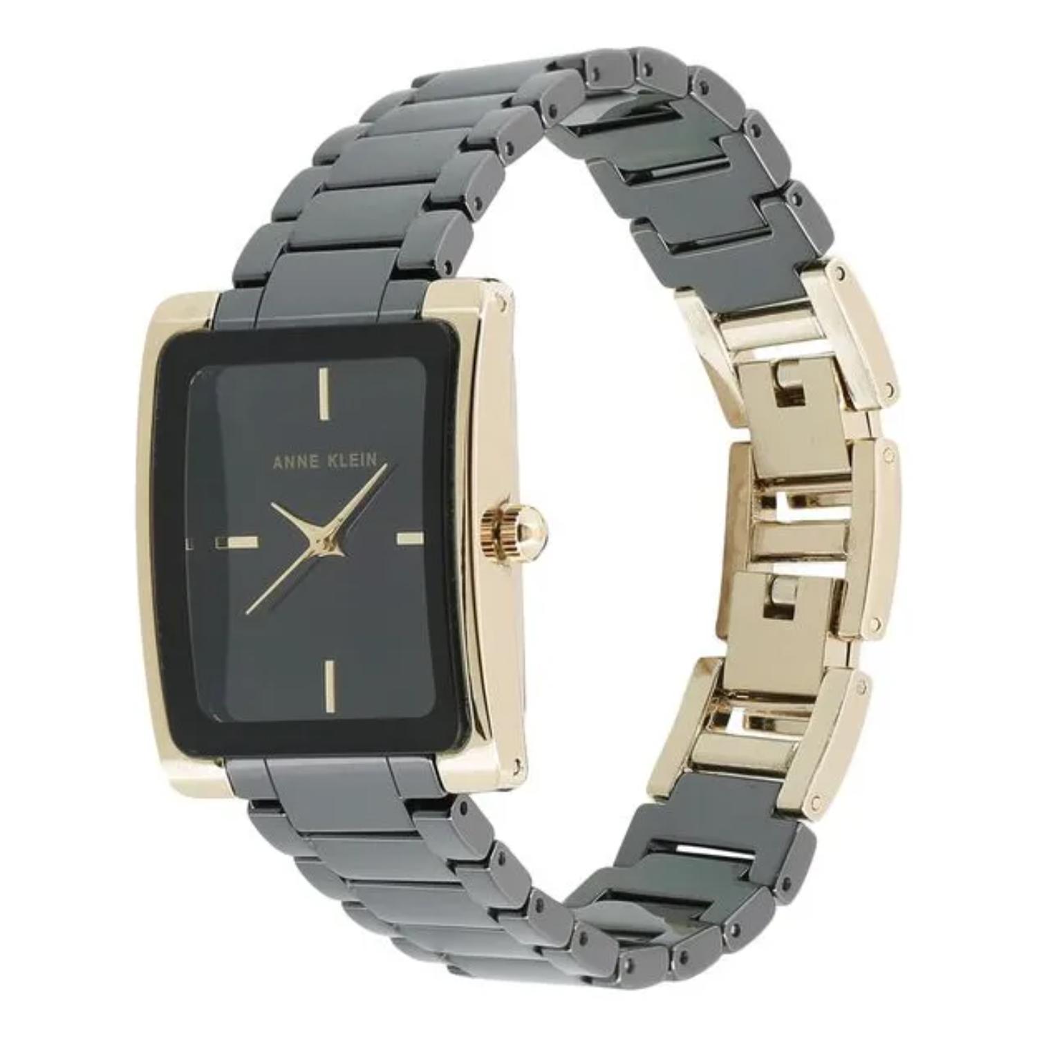 reloj Anne Klein AK/2952BKGB con caja rectangular dorada, esfera negra y brazalete metálico negro visto en ángulo lateral