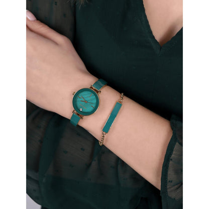 Anne Klein AK/3620GNST worn on the wrist with green mother-of-pearl dial, gold-tone case, green enamel bracelet, crystal marker, and matching green accent bracelet.