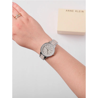 Anne Klein AK/1413LGSV with grey sunray dial, silver-tone case, and metallic silver bracelet worn on the wrist in an elegant everyday style.