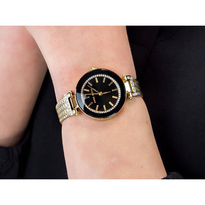 Anne Klein AK/1906BKGB with black dial, crystal-accented bezel, and gold-tone mesh bracelet worn on the wrist.