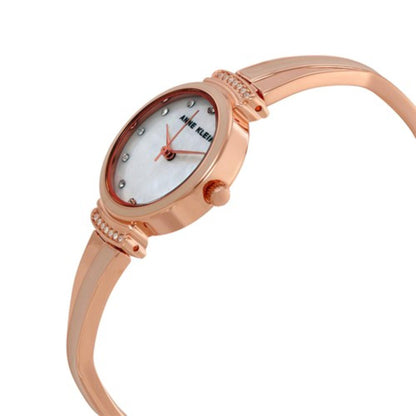 Anne Klein AK/2216BLRG with white mother-of-pearl dial, slim rose gold-tone case profile, crystal accents, and polished bangle bracelet.