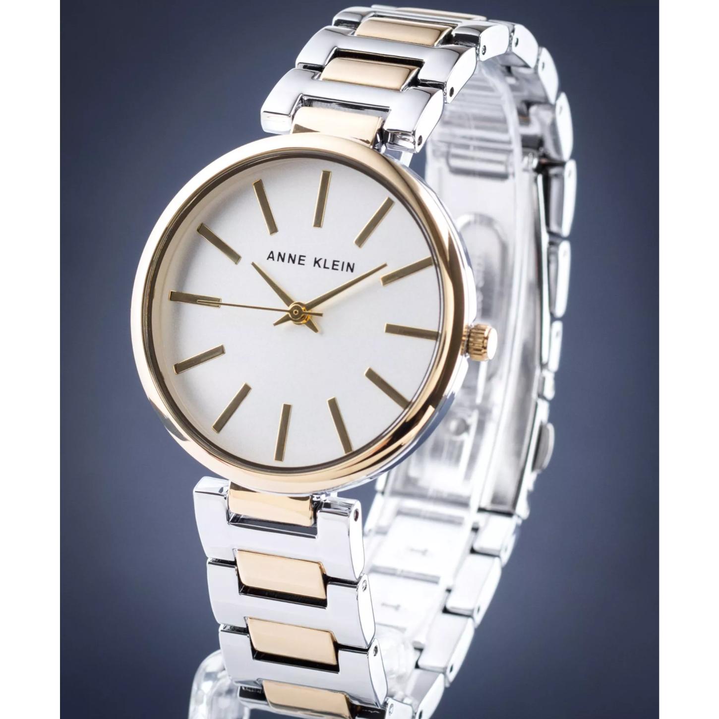 Reloj Anne Klein AK/2787SVTT en vista lateral tres cuartos, esfera blanca y brazalete bicolor plata y dorado en soporte