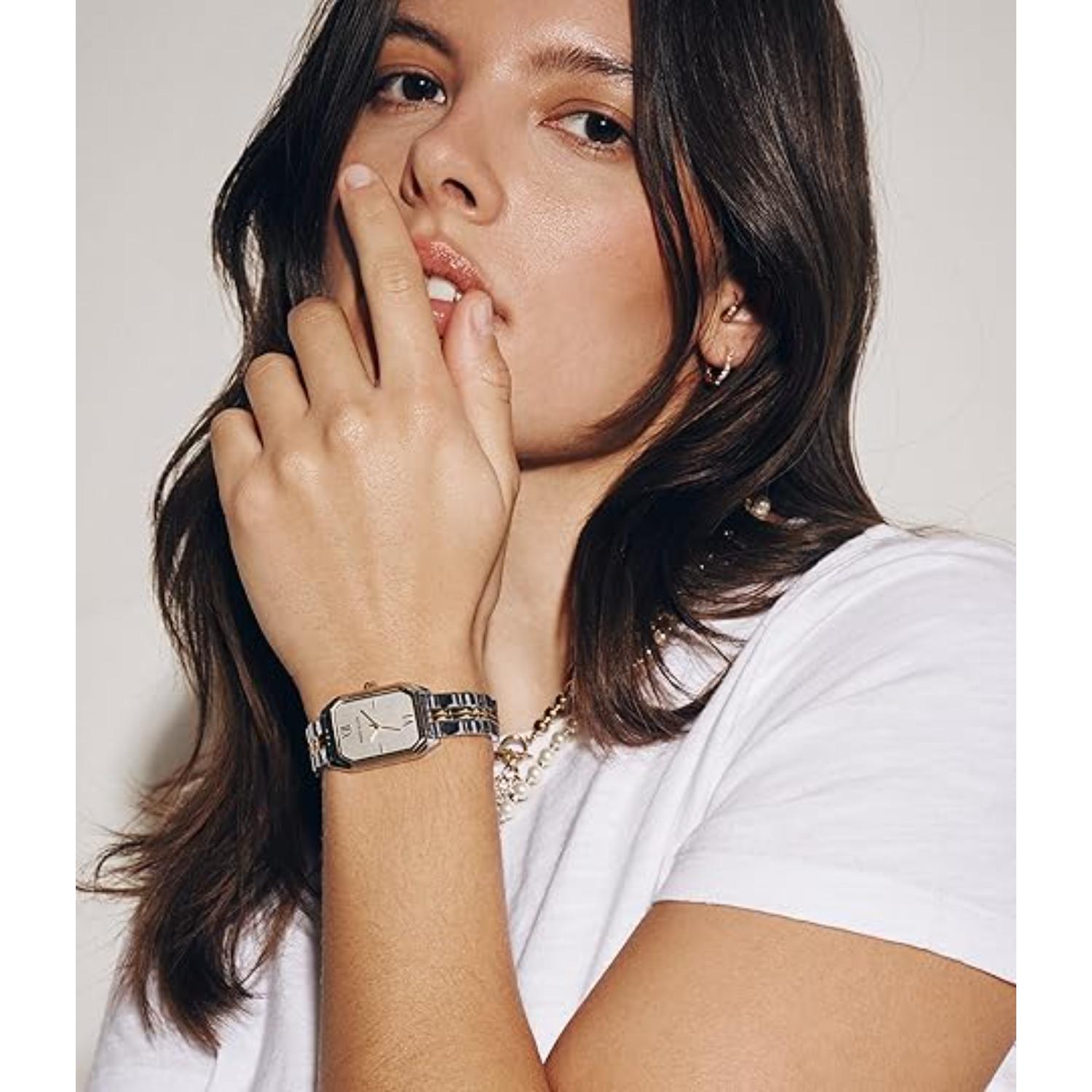Anne Klein AK/3775SVTT women’s dress watch worn on wrist with silver rectangular dial, gold-tone bezel accents and two-tone stainless steel bracelet paired with casual outfit.