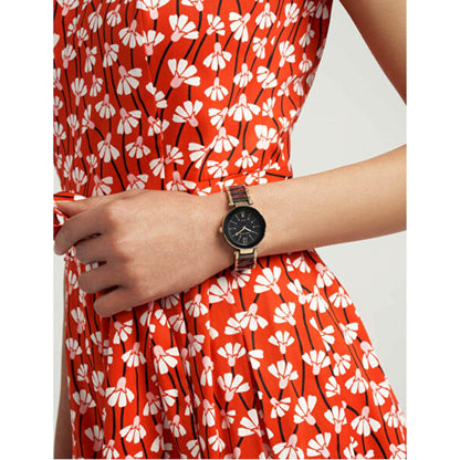 Anne Klein AK/3844BKGB women’s dress watch worn on wrist with black dial, crystal hour markers and black bracelet with gold-tone accents.