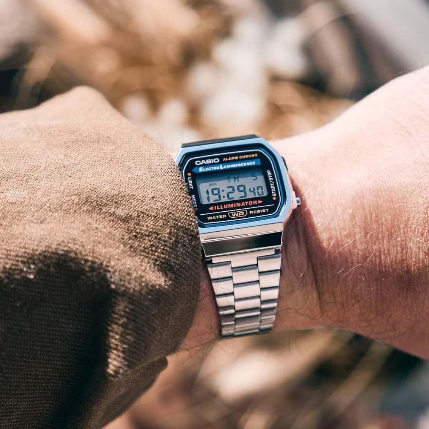 Casio A168WA-1 vintage digital watch with electro-luminescent display and stainless steel bracelet worn on the wrist in a casual everyday setting.