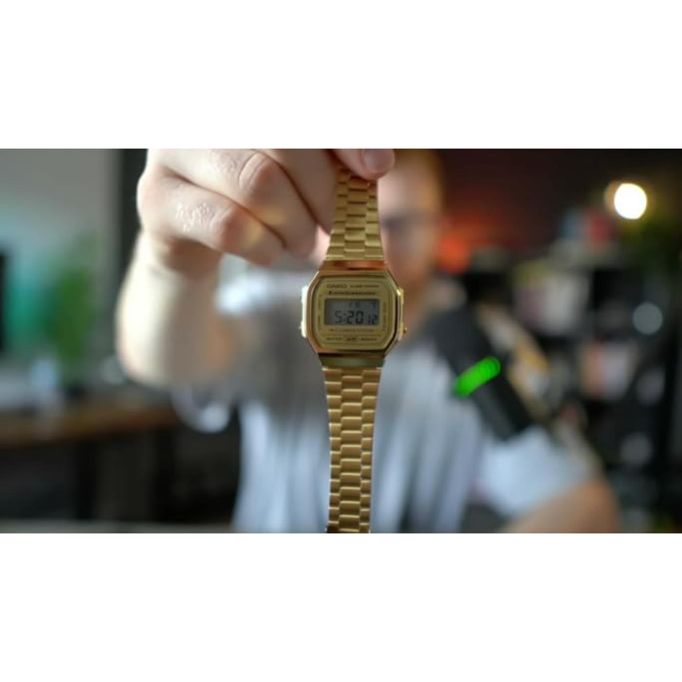 Casio A168WG-9UR vintage digital watch with gold tone case and stainless steel bracelet held in hand with classic retro design