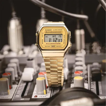 Casio A168WG-9UR vintage digital watch with gold tone case and stainless steel bracelet placed on audio mixer with retro style design