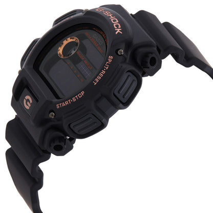 Casio G-Shock DW-9052GBX-1A4DR sports watch angled view highlighting the black resin case, pushers, and rose gold-tone branding details.