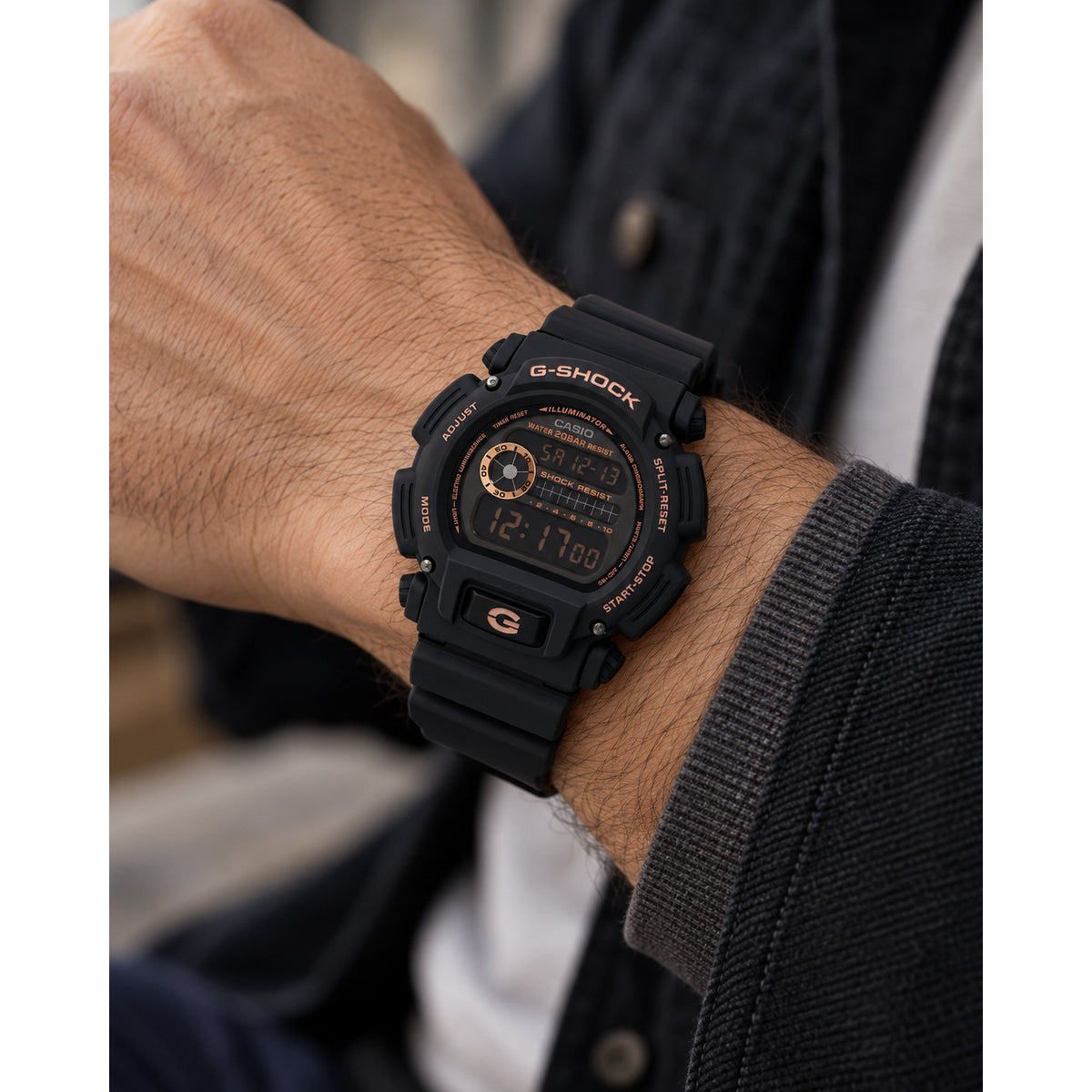Casio G-Shock DW-9052GBX-1A4DR men's digital sports watch worn on a wrist, displaying the black resin case and rose gold-tone dial accents.