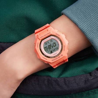 Casio G-Shock G-Squad GMD-B300SC-4DR women’s digital sport watch with a coral-tone case and strap, round digital display, and red accent details worn on the wrist.