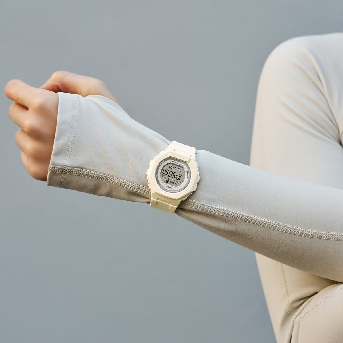 Casio G-Shock G-Squad GMD-B300SC-7 worn on the wrist with digital LCD display, white resin case and strap, gray bezel details, and subtle lime green accents paired with light activewear.