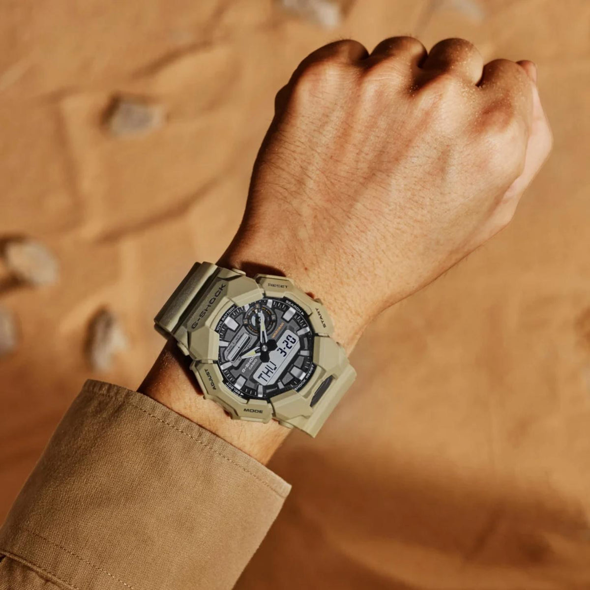 Casio G-Shock GA-010-5A men’s ana-digi watch with a black dial, dual digital displays, rugged beige case, and matching beige resin strap worn on the wrist.