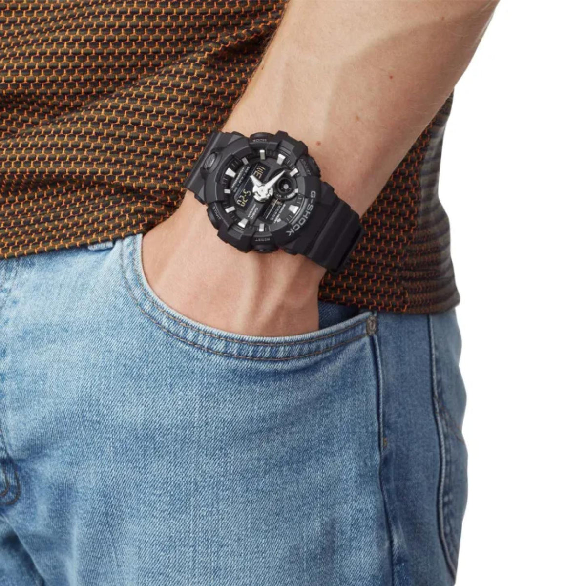 Casio G-Shock GA-700-1BCR men's ana-digi sport watch worn on wrist with striped shirt and jeans