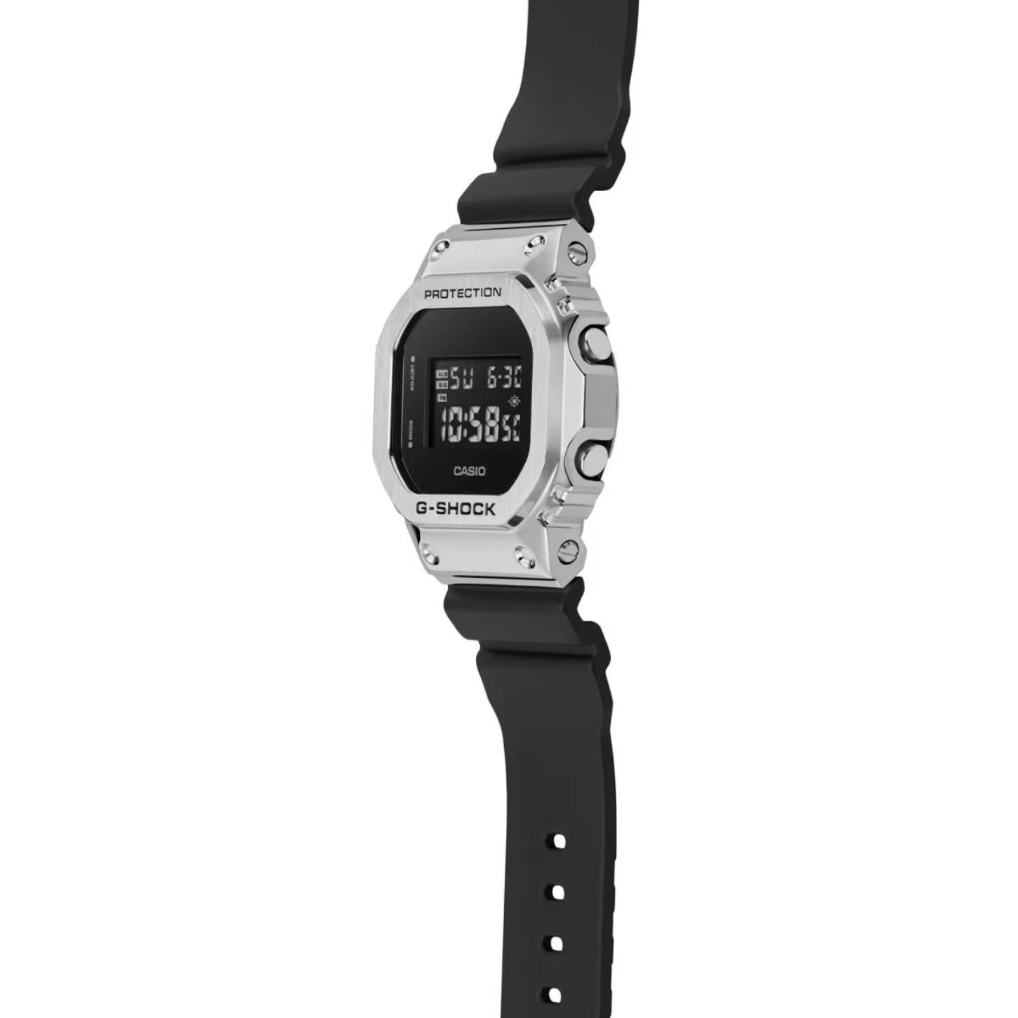 Casio G-Shock GM-5600U-1 from the side with a rectangular digital display, stainless steel bezel, raised silver-tone buttons, and black resin band.