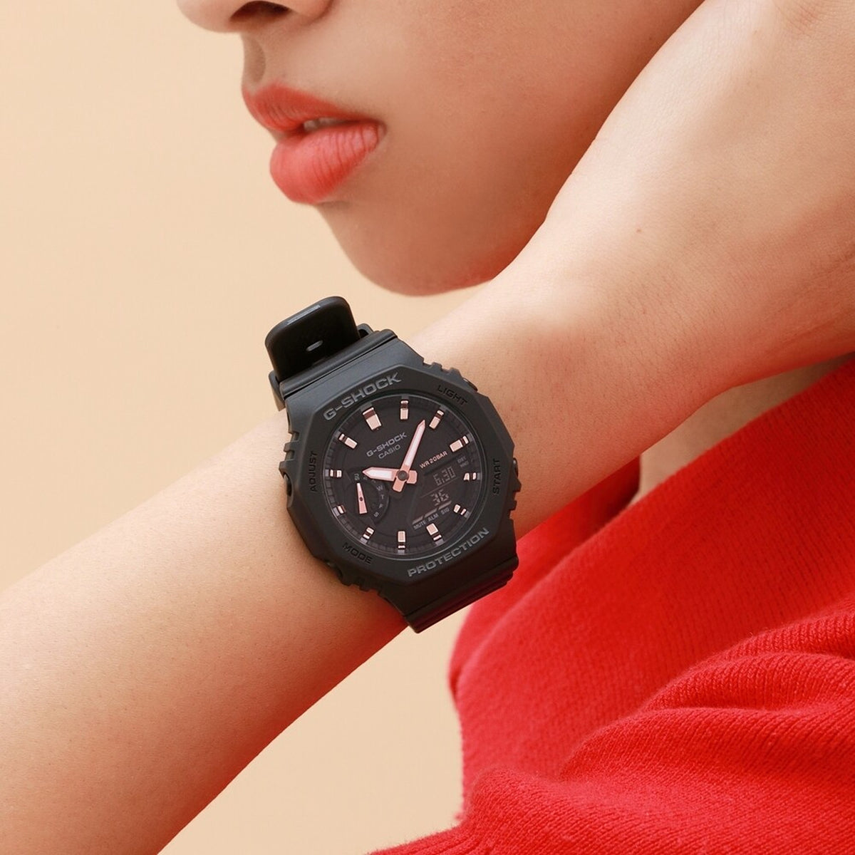 Casio G-Shock GMA-S2100-1A with a black octagonal case, black dial, rose gold-tone hands and hour markers, and a matching black resin strap worn on the wrist.