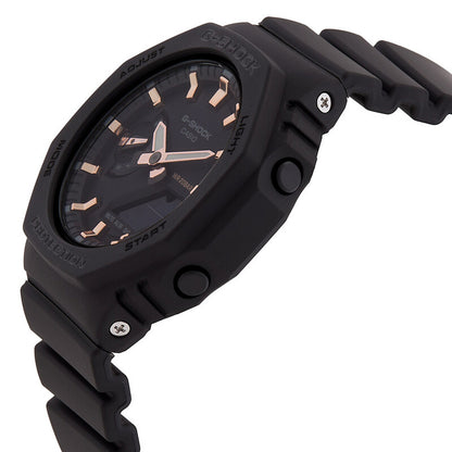 Casio G-Shock GMA-S2100-1A with a black octagonal side profile, exposed push buttons, visible screws, rose gold-tone hands and markers, and a matching black resin strap.