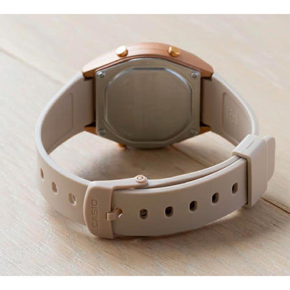 Vista trasera del Casio LW-204-4A con tapa de acero atornillada, caja en tono rosa y correa de resina beige con hebilla firmada.