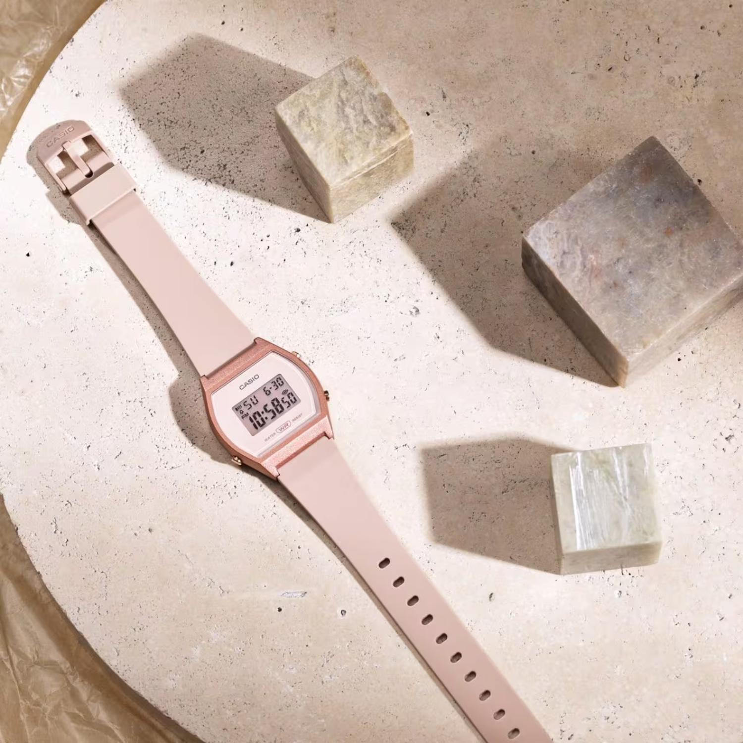 Casio LW-204-4A digital watch with pink resin case and strap shown in flat lay composition on neutral surface.