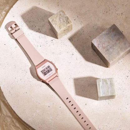 Casio LW-204-4A digital watch with pink resin case and strap shown in flat lay composition on neutral surface.