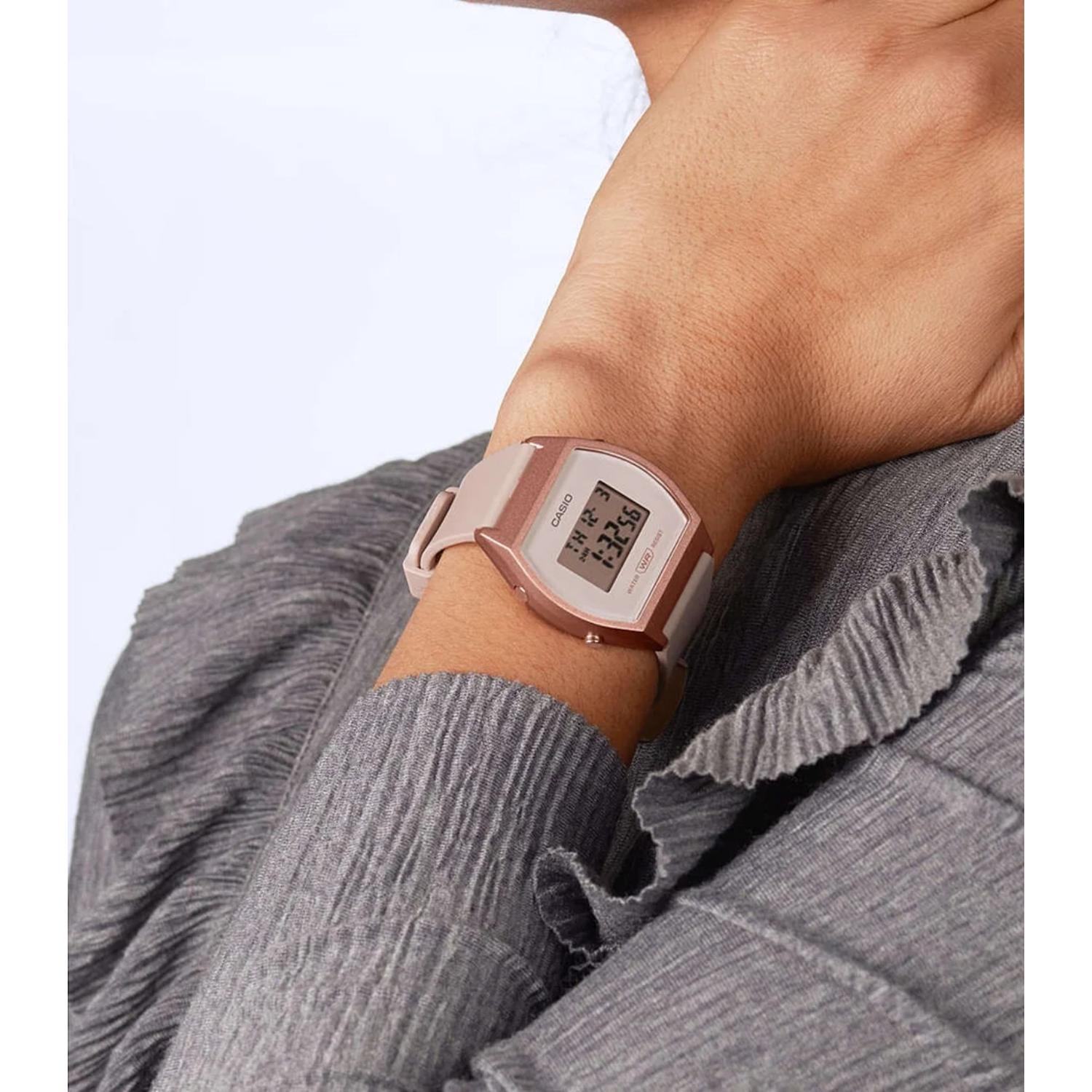 Casio LW-204-4A digital watch worn on the wrist with rectangular display, pink resin case and matching pink resin strap.