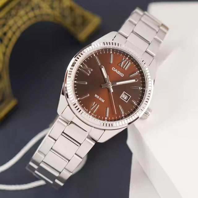 Reloj Casio de acero con esfera marrón visto en ángulo, mostrando caja pulida y brazalete metálico