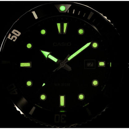 Casio MDV-107D-3A stainless steel dive watch with glowing luminous hands and markers displayed in dark lume close-up view.
