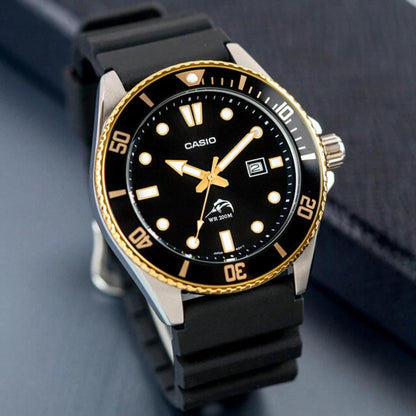 Casio MDV106G-1AV quartz dive watch with black dial, gold tone bezel, luminous markers and black rubber strap shown in angled view with stainless steel case