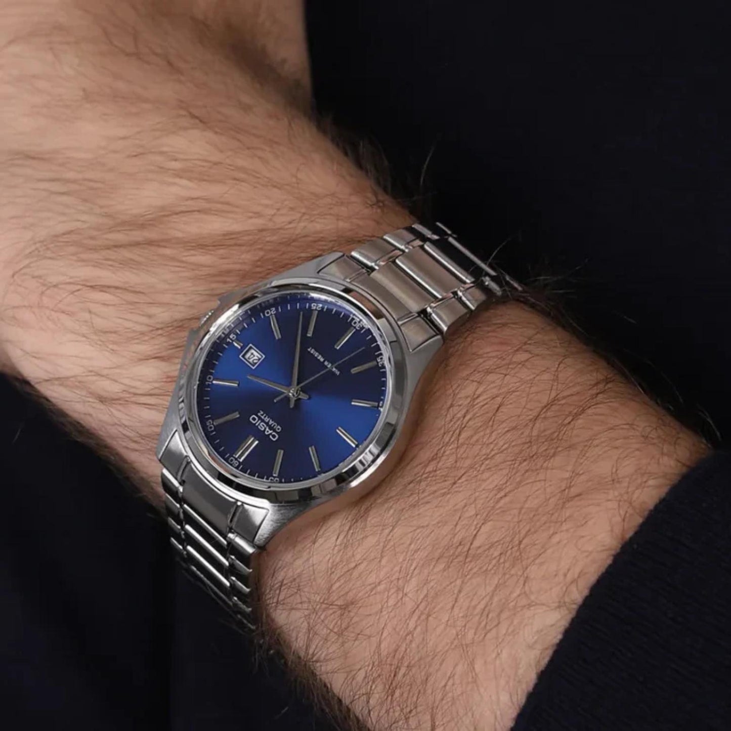 Casio MTP-1183A-2A men’s dress watch worn on wrist with blue sunray dial, date display and stainless steel bracelet.