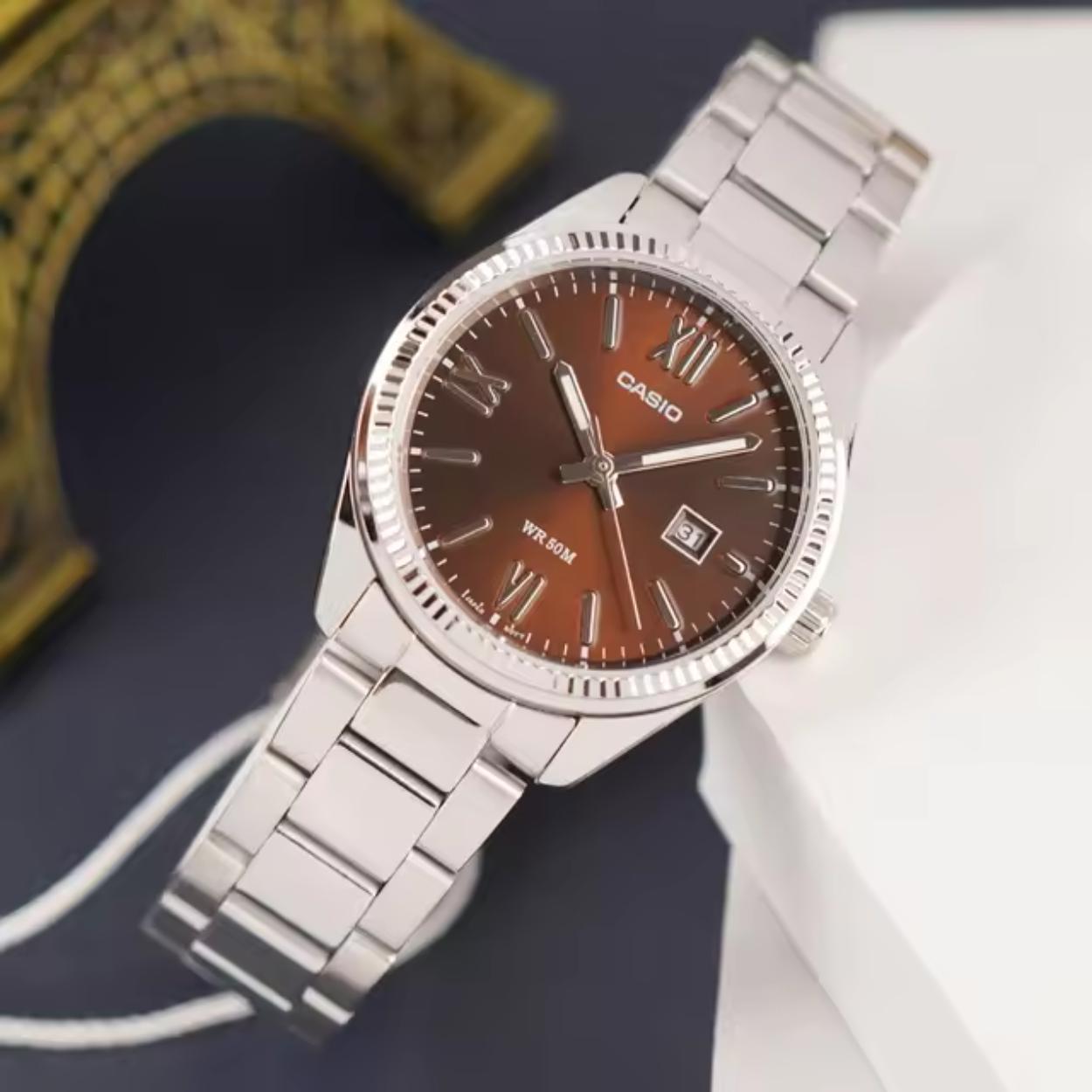 Casio MTP-1302DD-5AV watch with brown dial and stainless steel bracelet shown in lifestyle setting.
