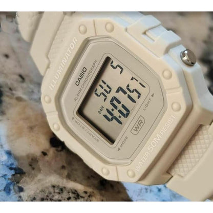 Detalle de la pantalla digital del Casio W218HC-8AV en color beige, mostrando función Illuminator, cronógrafo y resistencia al agua 50M.