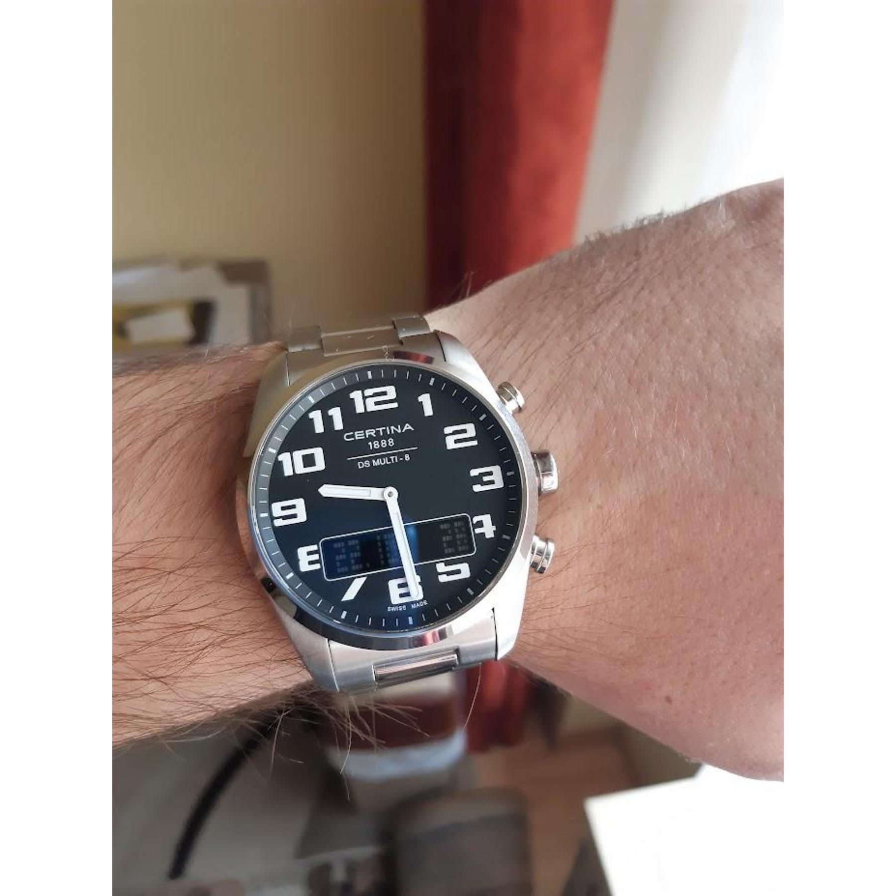 Certina C020.419.11.052.01 ana-digi watch worn on the wrist with black dial, analog hands, digital display and stainless steel bracelet.