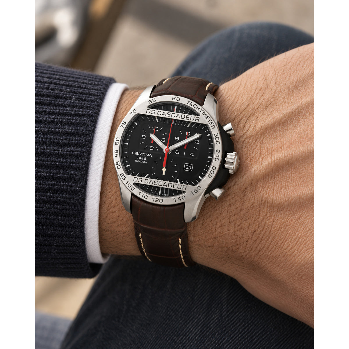 Certina DS Cascadeur quartz chronograph watch worn on a man's wrist, highlighting the black dial and brown leather strap.
