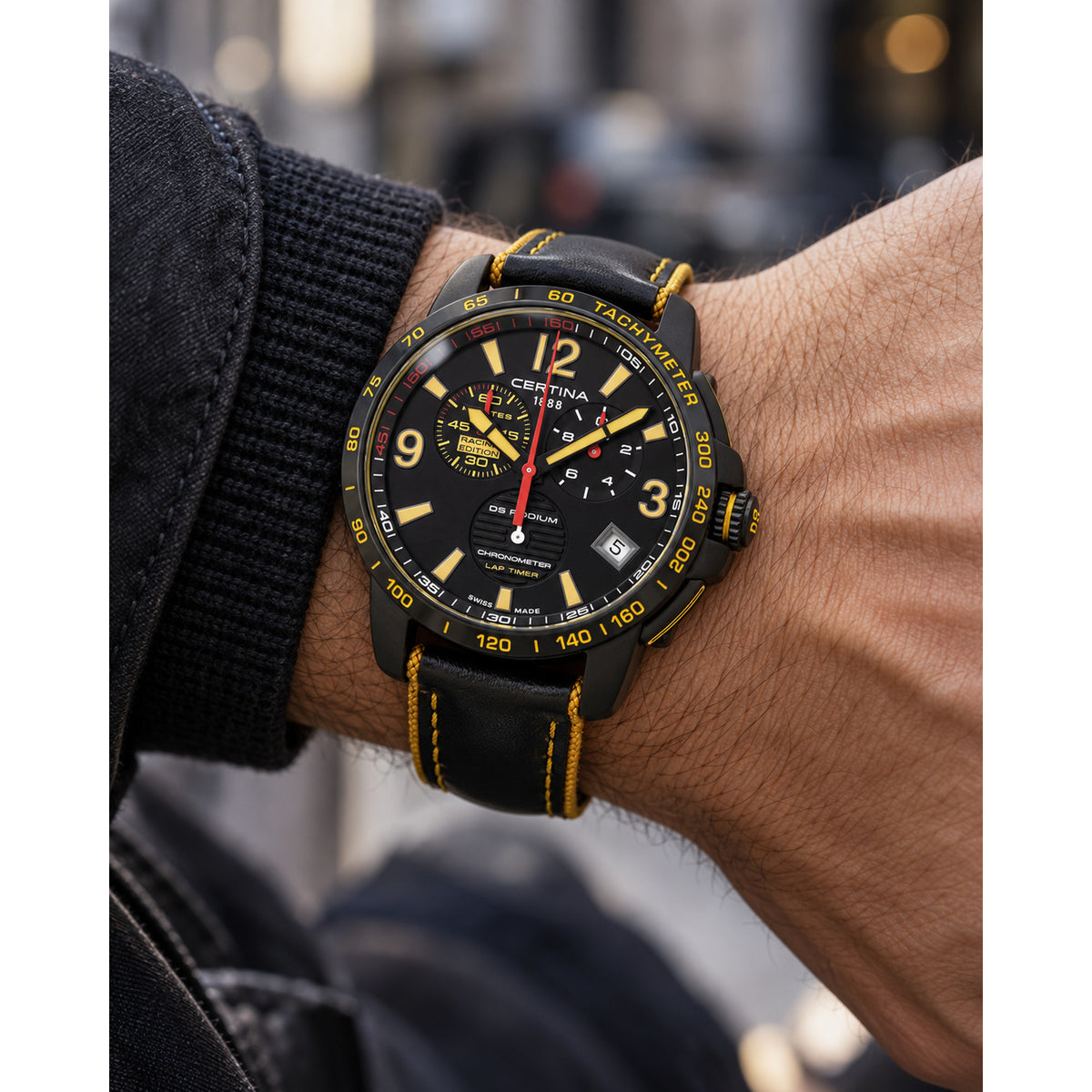 Certina DS Podium quartz chronograph watch worn on wrist, highlighting the black dial and yellow stitching on the leather strap