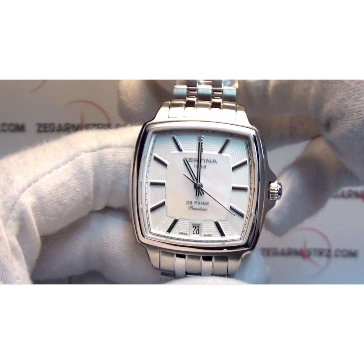 Certina DS Prime Shape C028.310.61.116.00 con esfera de nácar y diamantes, mostrado en mano con guantes, caja cuadrada de acero y brazalete metálico.