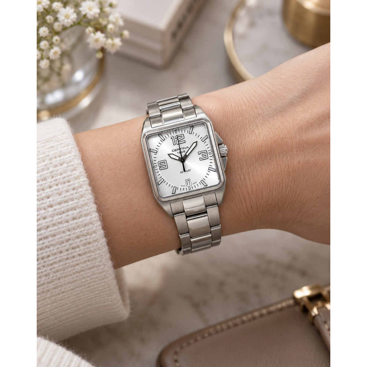 Certina DS Trust women's watch featuring a rectangular stainless steel case, silver dial with Arabic numerals, and a matching steel bracelet worn on the wrist