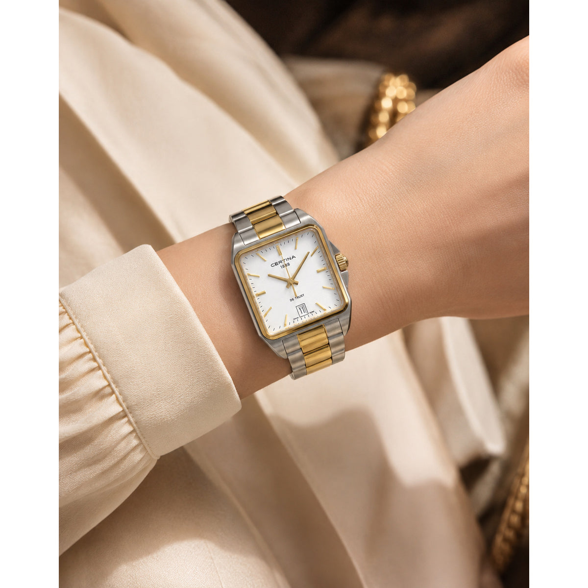 Certina DS Trust C019.510.22.031.00 with a silver dial, gold-tone hands and hour markers, rectangular case, and two-tone bracelet worn on the wrist.
