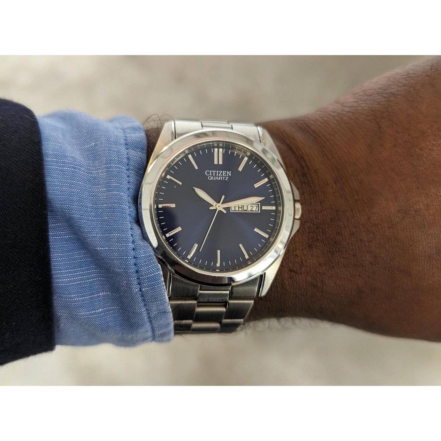 Reloj Citizen Quartz BF0580-57L con esfera azul y brazalete de acero inoxidable, colocado en la muñeca.