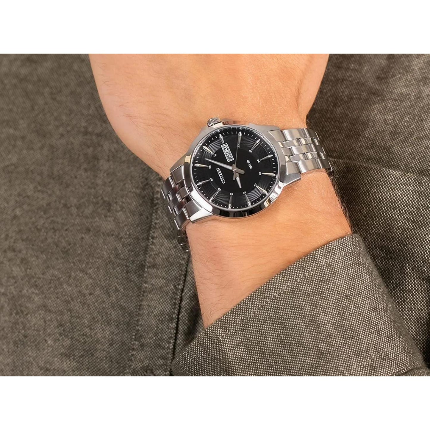 Reloj Citizen BF2011-51E con esfera negra y brazalete de acero inoxidable, colocado en la muñeca.