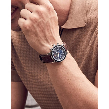 Citizen CA0648-09L Eco-Drive chronograph worn on the wrist with blue dial, tachymeter bezel, stainless steel case and brown leather strap.