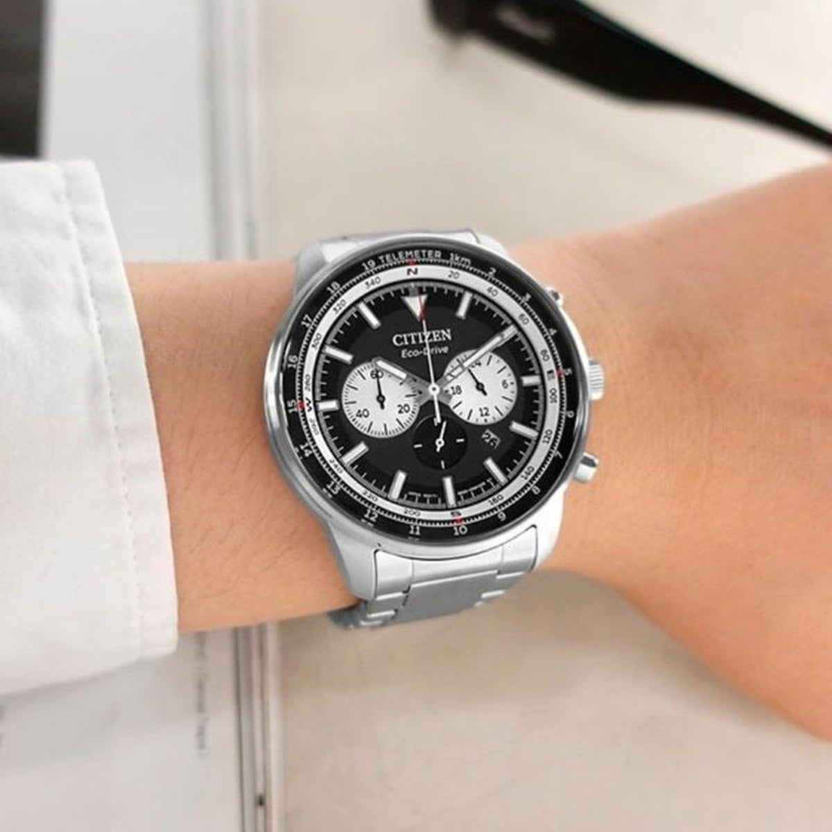 Citizen CA4500-91E Eco-Drive chronograph with a black dial, contrasting white subdials, telemeter scale, and silver-tone bracelet worn on the wrist.